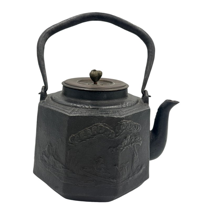 JAPANESE CAST IRON TETSUBIN/TEAPOT WITH LANDSCAPE SIGNED: Decorated with an irregular, textured surface and an elegant, arched handle, this Japanese teapot was used to boil water for traditional tea ceremonies. Known as tetsubin, the kettle's cast-iron const