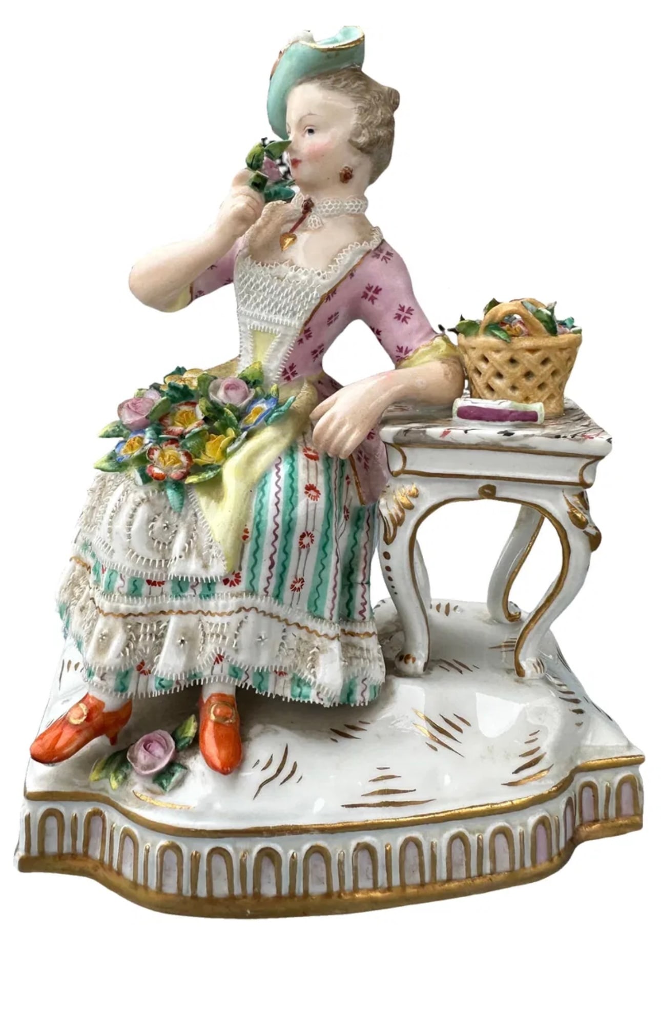 Meissen (German) Painted Porcelain Figurine, Sense of Smell: Meissen (German) Painted Porcelain Figurine, Sense of Smell from The Charleston Living Estate of Lynn Letson H 6" W 4" Depth 3" | Depicting a seated lady smelling a bouquet of flowers, adjacent to a b