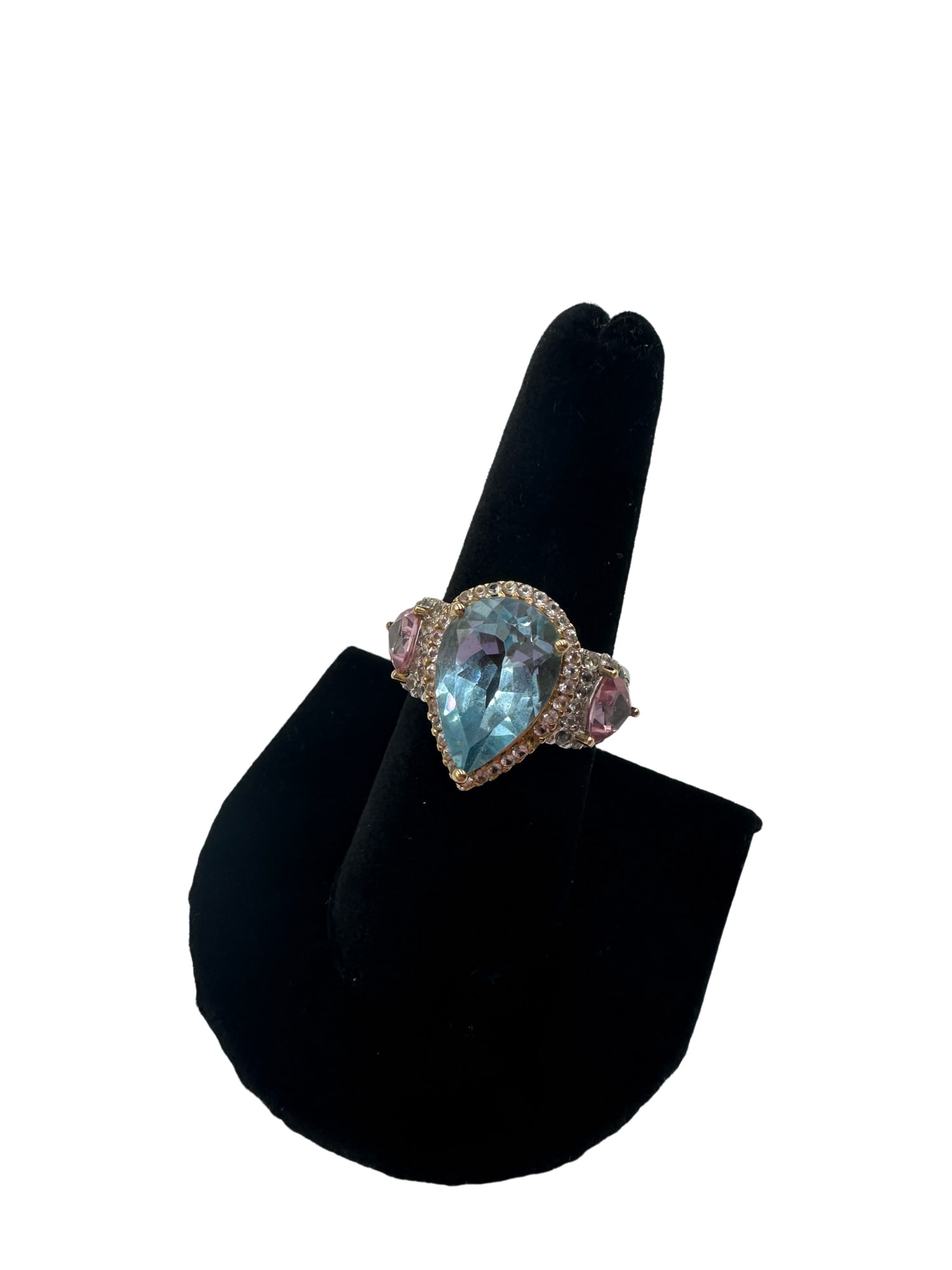 14K White and Yellow Gold ‘ The Getty Ring ‘: Spare no extravagance with this must-have cocktail ring featuring a pear-shaped 7.16 carat blue topaz center stone, two trillion-cut 1.82 carat pink topaz side stones and diamond cut white sapphires.