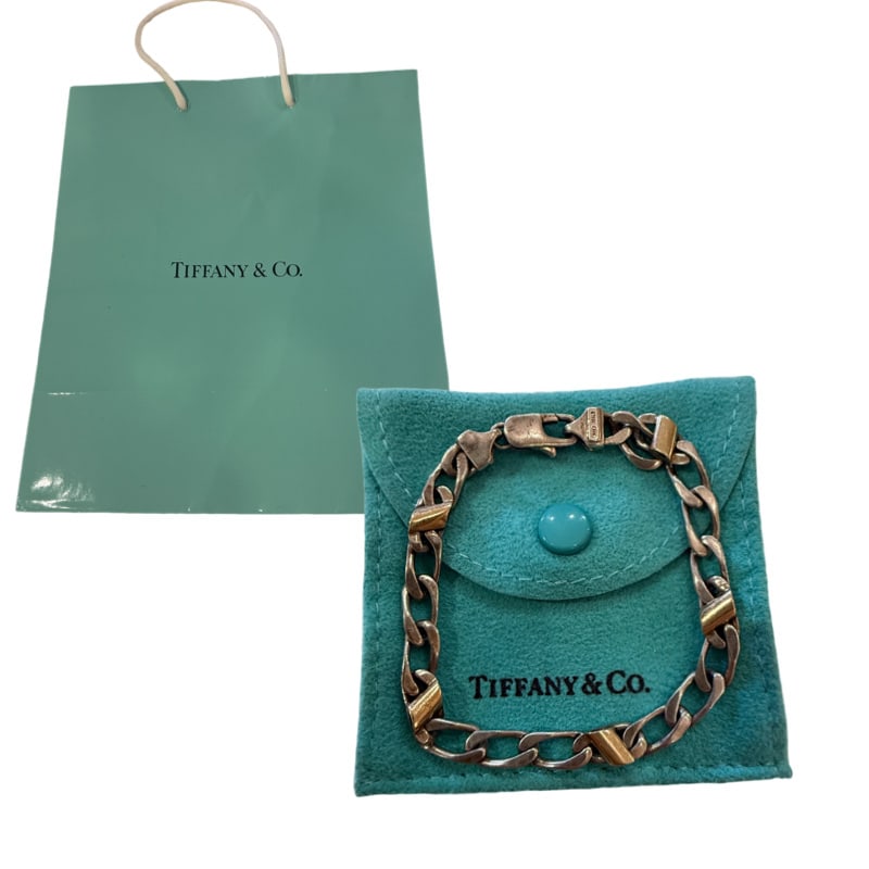 Tiffany & Co. Sterling Silver and 18K Yellow Gold Cuban Link Bracelet: PLEASE READ: in house shipping within the US If you win this item, please select self arranged for in house shipping when paying invoice A sterling silver Cuban link bracelet by Tiffany & Co.