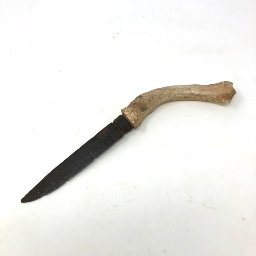 Early Patch Knife with an Antler Curved Handle: An early patch knife with an antler curved handle. Rusted and “deteriorated” end to antler handle, as dug. But a solid and complete knife with an iron ferrule. 5 1/4” long x 7/8” w