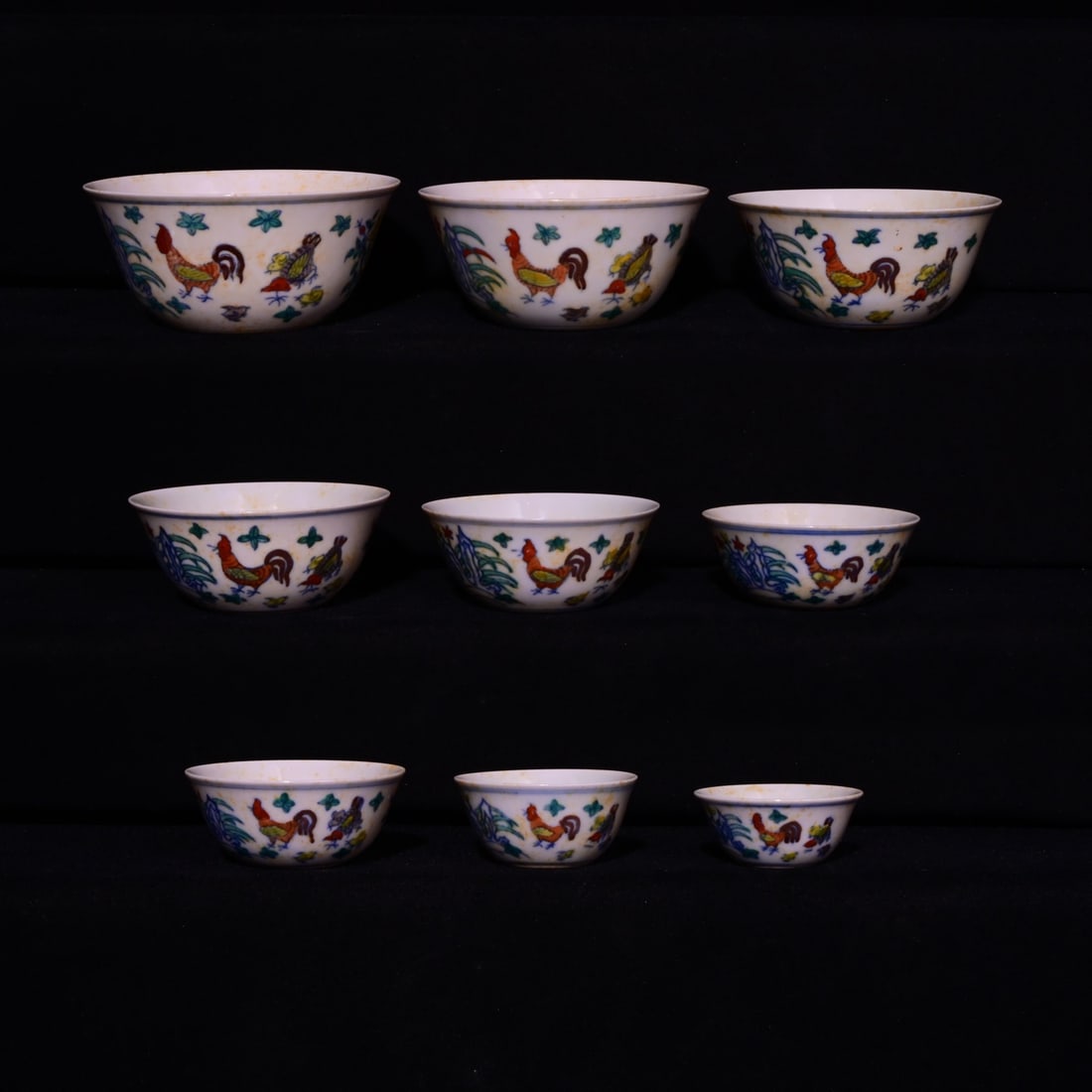 A set of nine chicken-themed cups in the style of the Chenghua period of the Ming Dynasty.: A set of nine chicken pattern cups in Chenghua style of the Ming Dynasty, the largest measures 5x1.5 cm, the smallest measures 2x4.7 cm
