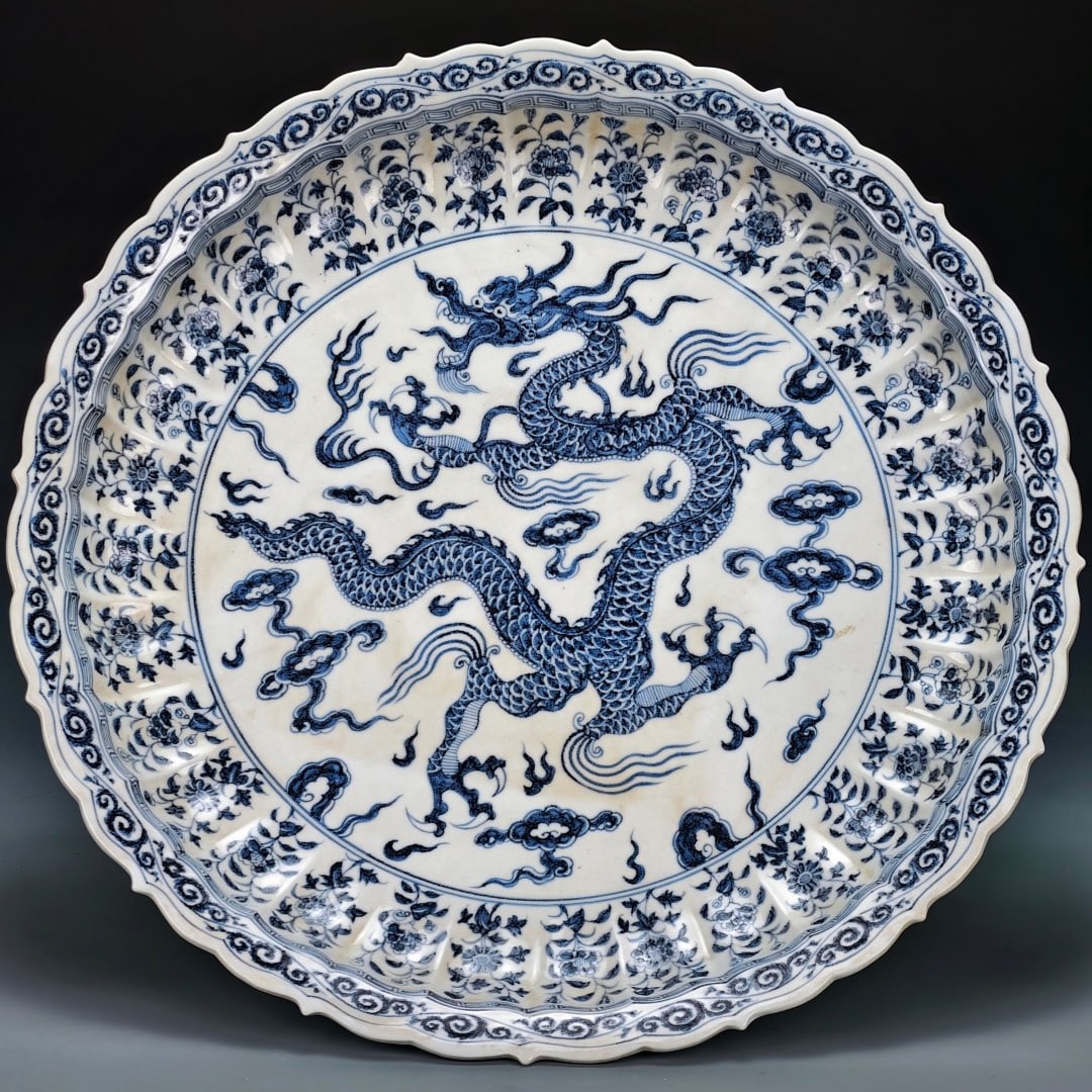 A celadon-glazed melon rib and openwork sunflower mouth dish with a side view of a dragon design: A celadon porcelain plate with a dragon design from the late Yuan to early Ming dynasty, 8cm in height and 70cm in diameter.