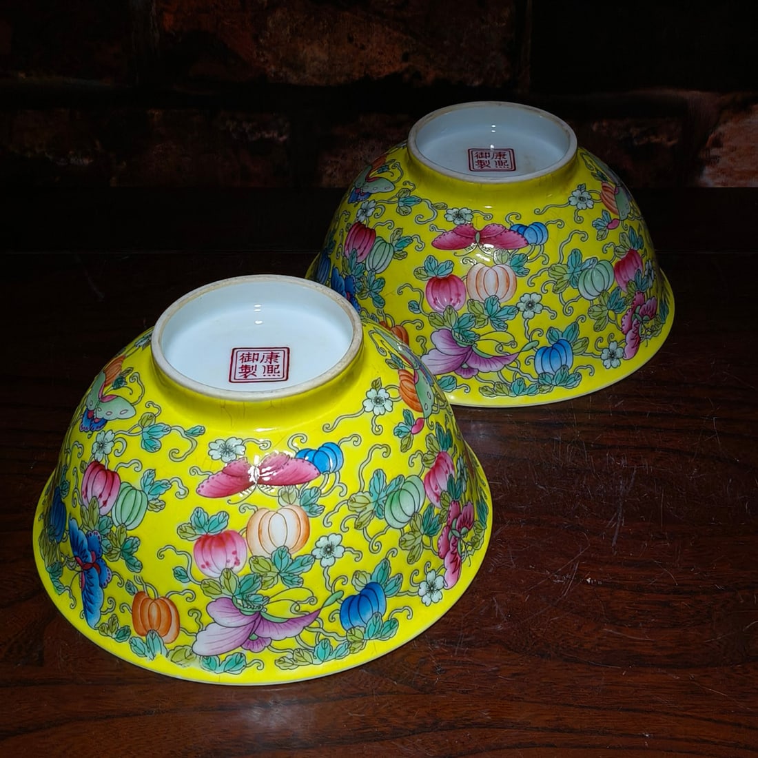 Enamelled Kangxi-style yellow ground melon vine pattern bowl pair: A pair of famille verte Kangxi-style yellow ground melon-trellis pattern bowls, diameter 15cm, height 7.3cm, with butterfly motifs, 'butterflies and flowers bring prosperity', thick glaze, and fine cr