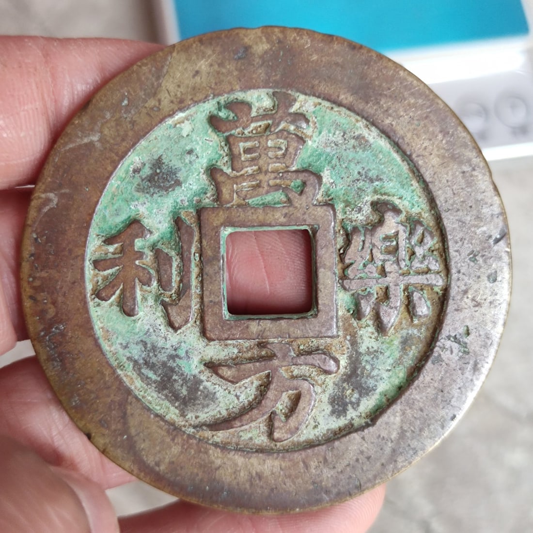 A piece of coin with the inscription 'Wan Fang Le Li Si Hai Sheng Ping' (1 of 8)