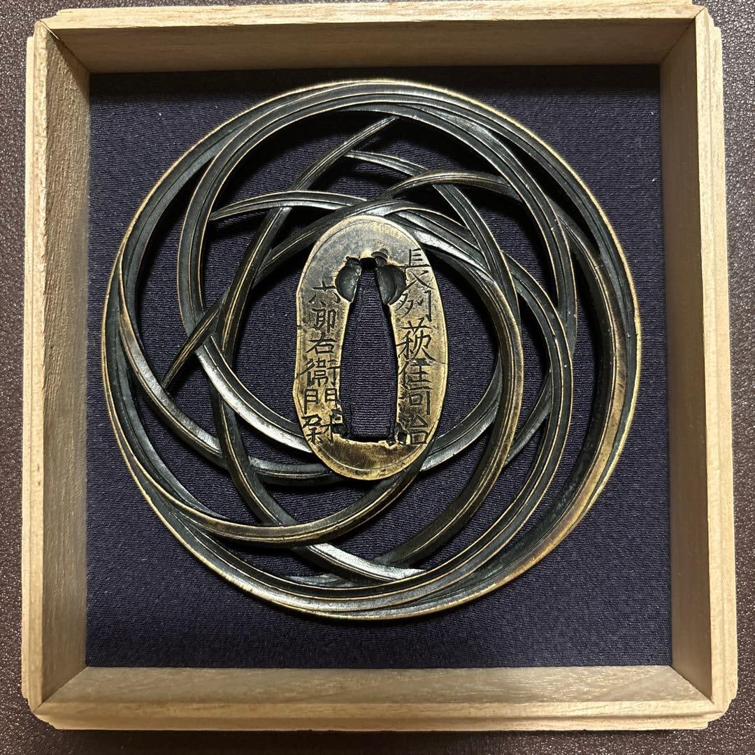 In the late Edo period, a sword with a reed pattern made by Kawachi Rokuroemon Tomonao from Hagi,: This is a brass sword guard with the original box. It has a diameter of 8.8 centimeters. Chikanao Kuni (Rokuroemon) was born in Choshu and is the second son of Chikanao Michimichi.