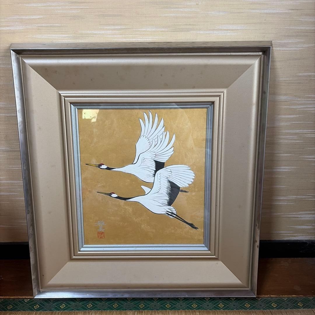 A painting of Japanese cranes set against a gold background.: A Japanese painting depicting cranes against a golden background. Subject: Cranes Background: Gold Signature: Artist's signature and seal Frame: Decorative frame