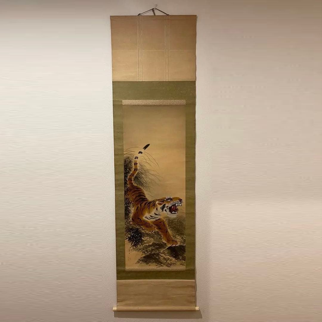 Hanging Scroll with Tiger Pattern: This is a Japanese painting depicting a tiger, characterized by a golden brocade border. Technique: Japanese painting Subject: Tiger Decoration: Brocade border Signature: With artist's seal