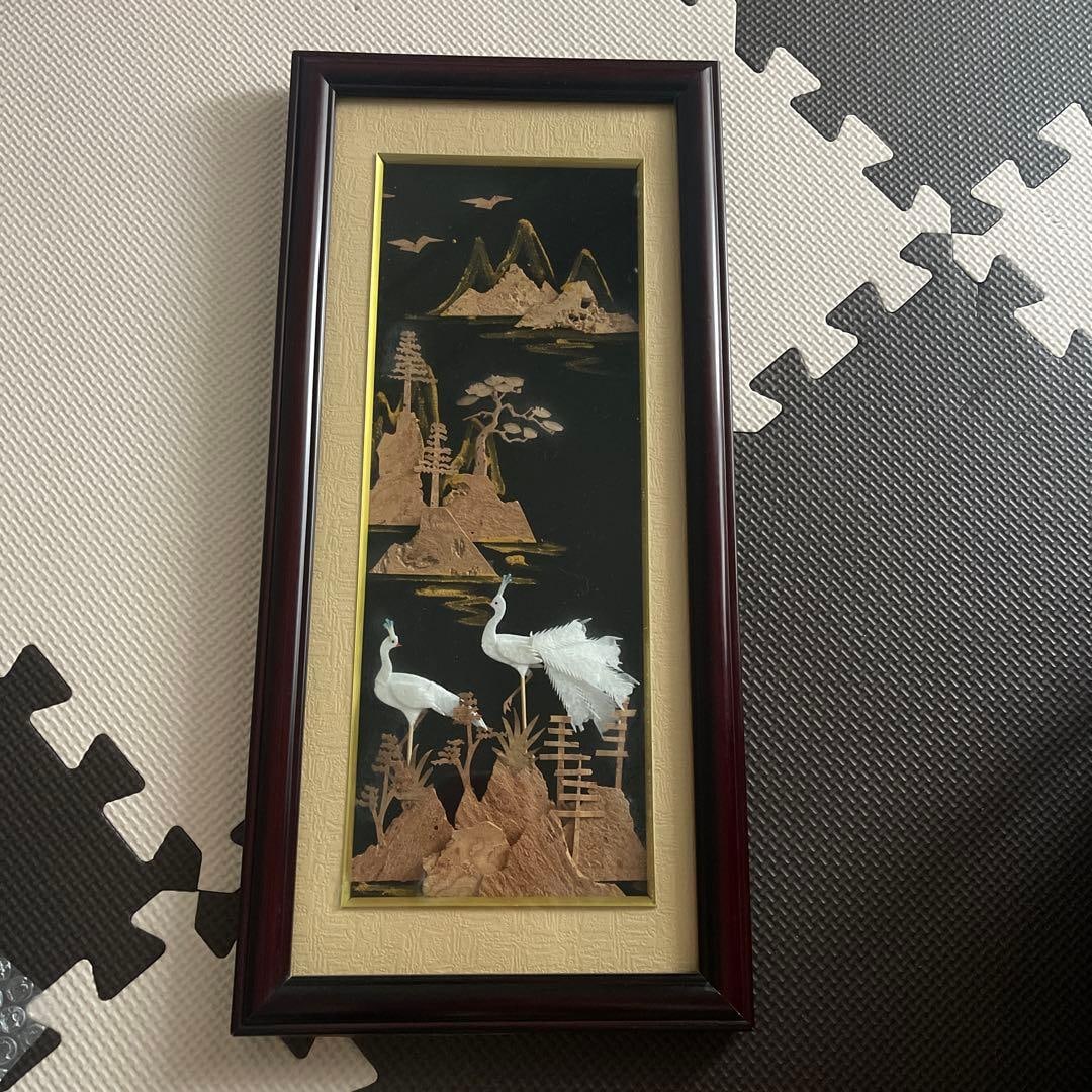Japanese Painting: Cranes and Landscape, Wall Hanging: A Japanese painting depicting cranes in gold and white against a black background. Style: Japanese painting Primary materials: Paper, wood, gold leaf Colors: Black, gold, white Design: Cranes and land