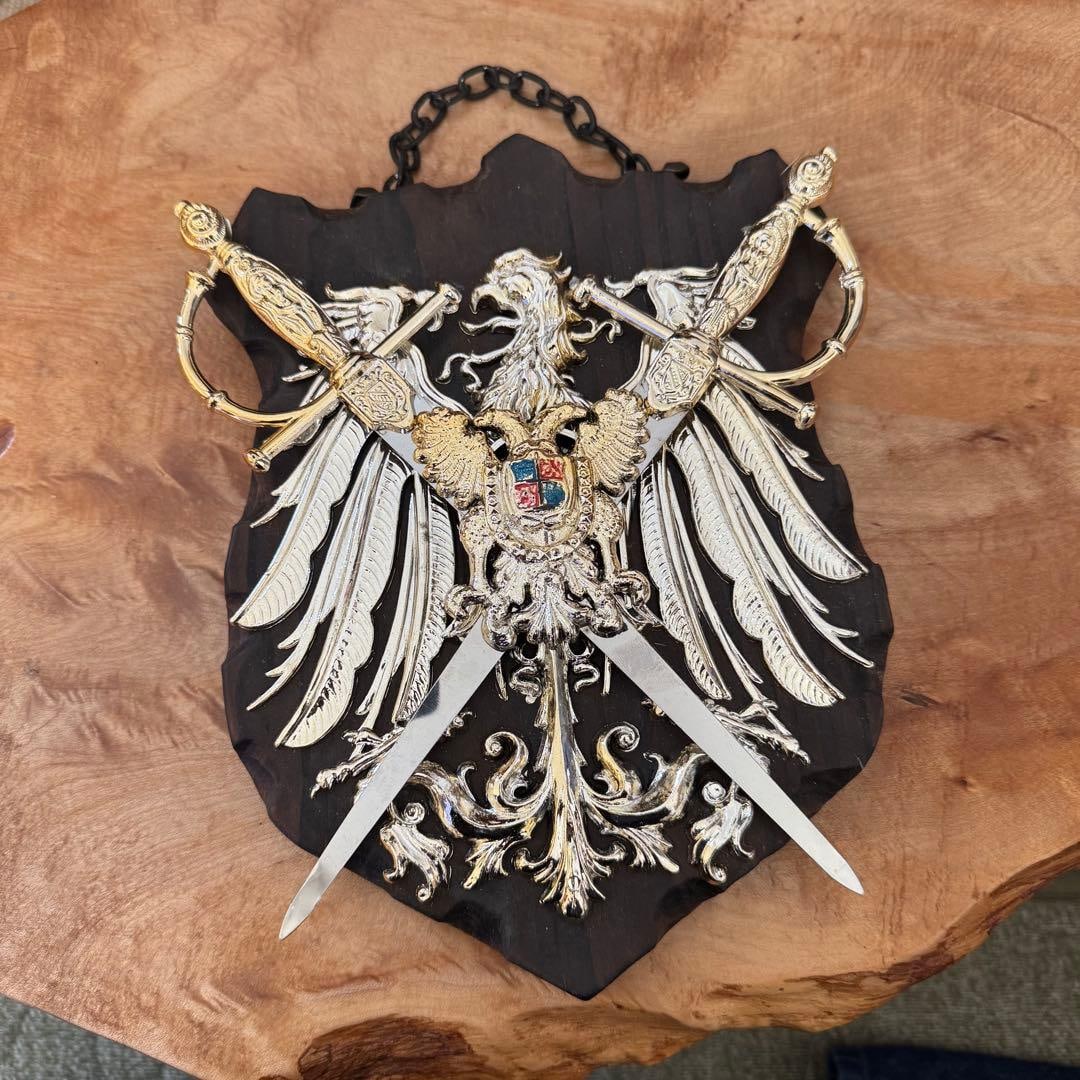 A shield and sword carved with two eagles.: A medieval-style decorative piece, consisting of a wooden shield carved with two eagles and a sword. Design: Shield-shaped ornament, carved with two eagles Material: Wood, metal embellishments Accesso