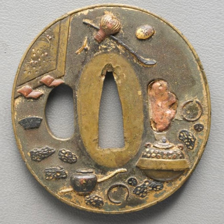 Sword Guard (Tsuba): This is a sword guard from the Edo period. Its shape closely resembles that of a painted coin. The design is unique, distinctly different from common sword guards, and the exquisite craftsmanship and 