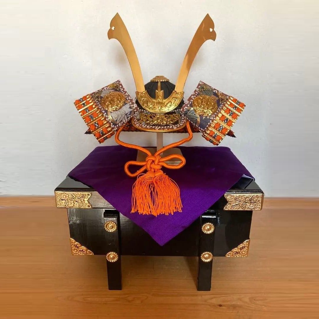 Miniature Helmet: This miniature samurai helmet and armor set is crafted with purple fabric and gold embellishments. Its compact size makes it ideal for modern homes, allowing it to be easily placed anywhere. Type: May