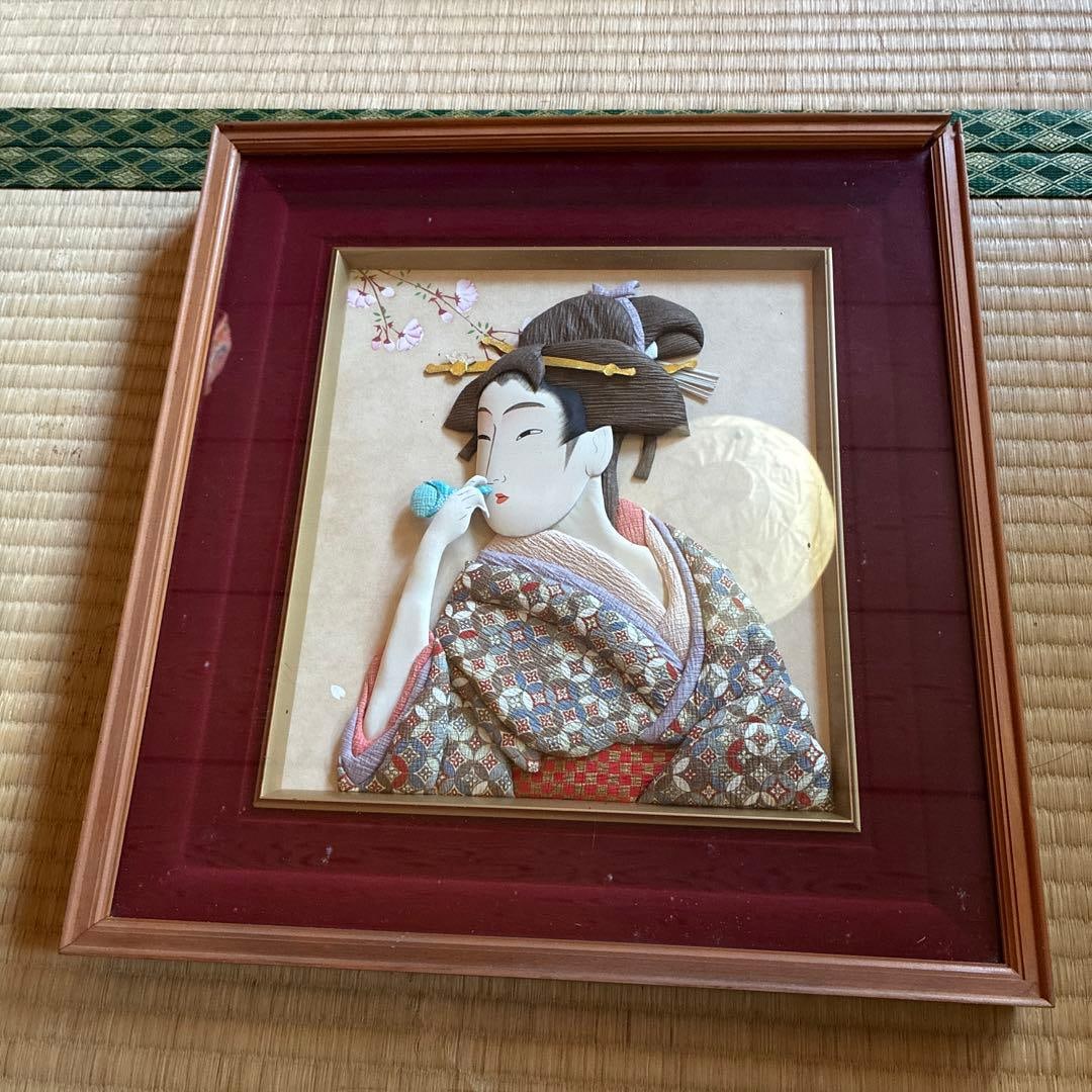 Japanese crafts, ukiyo-e prints, Japanese paintings, Showa retro style.: This is a portrait of a beauty in Japanese style, crafted using the oshie (applique) technique. It is made with washi paper, featuring a three-dimensional structure similar to chirimen crafts. It poss