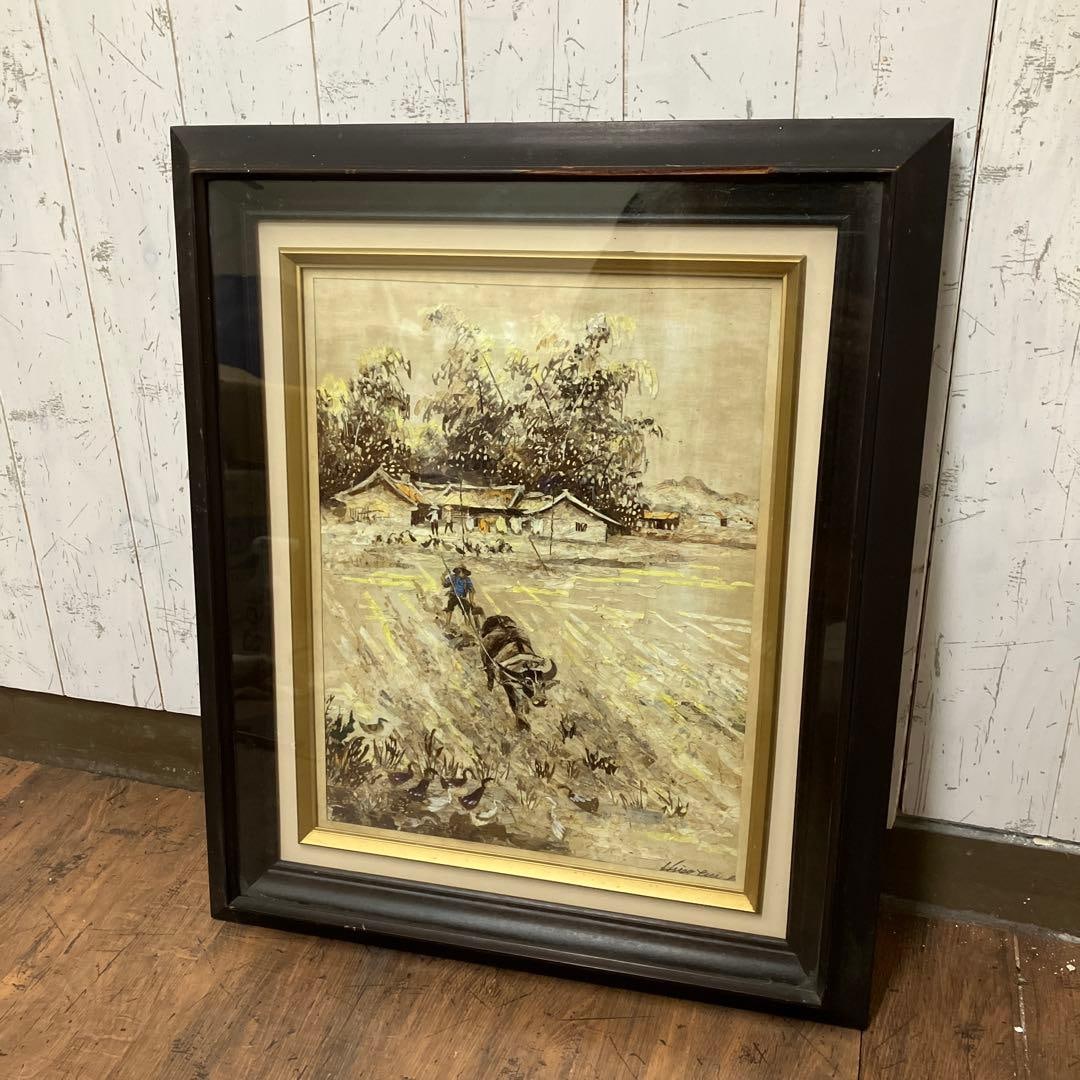 Showa-era retro landscape painting, framed artwork.: Characteristics of the Artwork Theme: A tranquil rural scene depicting a farmer driving a water buffalo to plow the field. In the background, thatched-roof houses are arranged in an orderly manner, pr