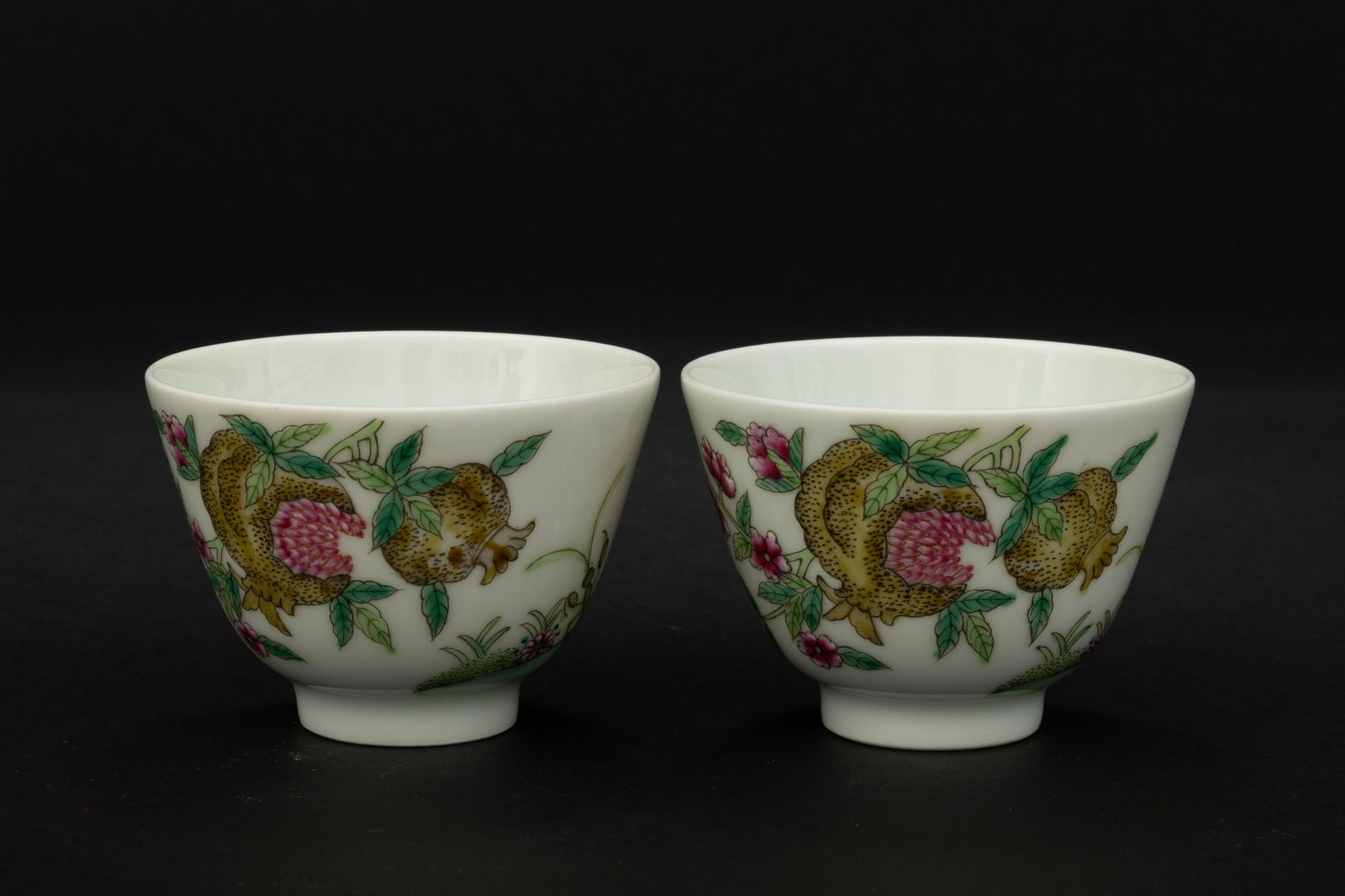 A pair of Qing Tongzhi pastel pomegranate pattern cups: H: 2 in. (5.3 cm) D: 2.8 in. (7.3 cm)