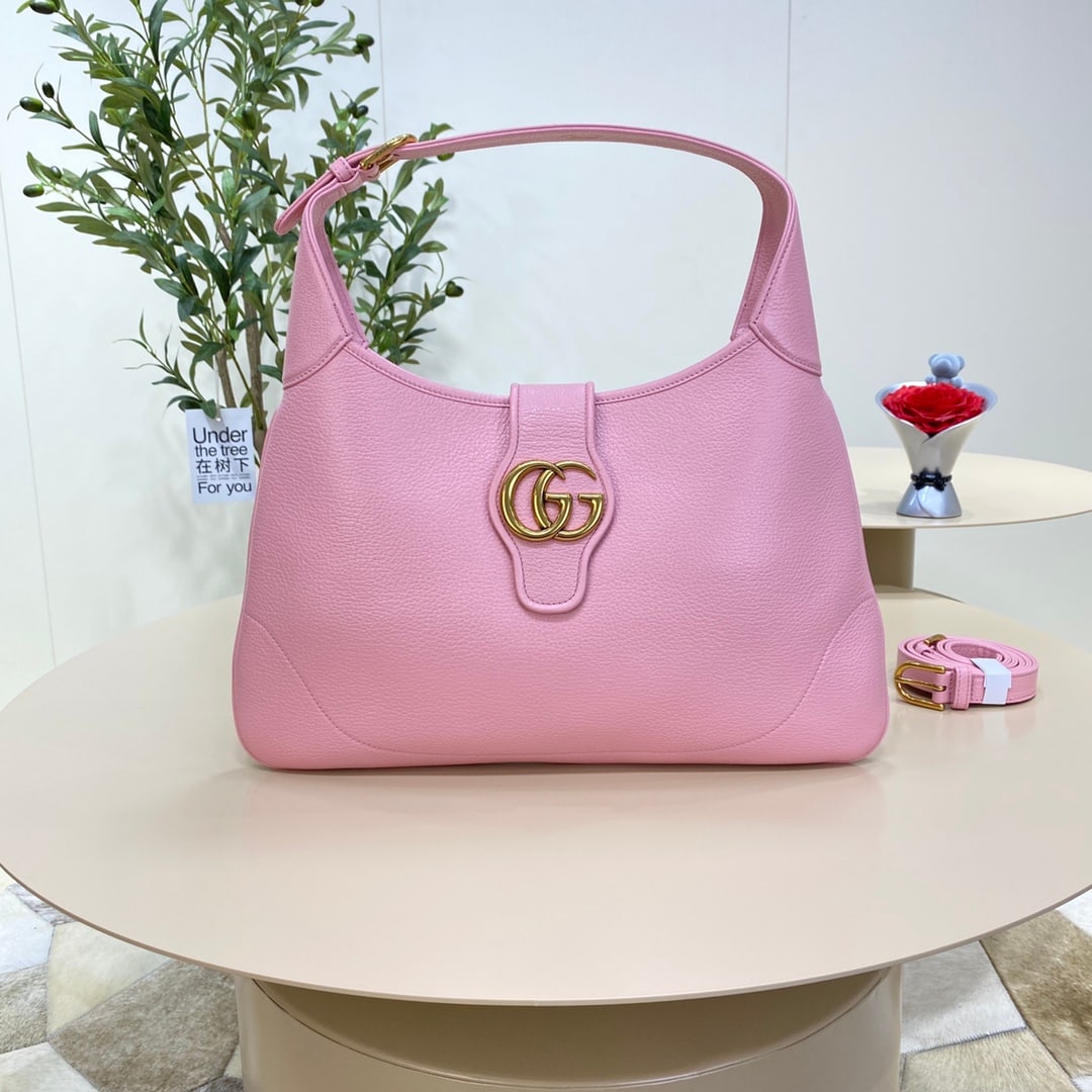 GUCCI Aphrodite: The GUCCI Aphrodite medium crescent bag in light pink (Gu Cosmogonie) from the collection debuted at the historic Monte Fortress in Italy. The show showcased a blend of aesthetic elements from differe