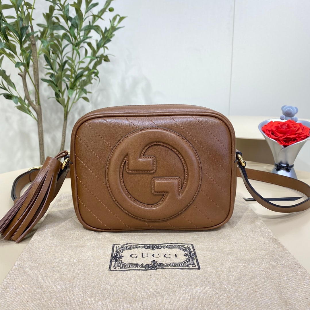 GUCCI Blondie: The GUCCI Blondie camera bag in brown features a circular, interlocking double G design inspired by the brand's heritage, a testament to the GUCCI Blondie collection. This classic GUCCI Blondie