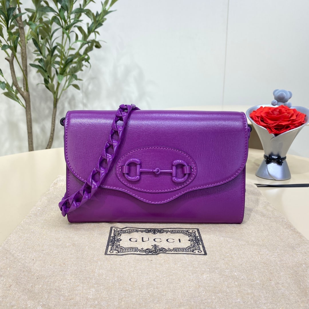 GUCCI Horsebit 1955: The GUCCI Horsebit 1955 chain envelope bag, in purple and mini size, features two detachable shoulder straps: one with classic red and blue webbing, and the other with the recognizable GUCCI chain,