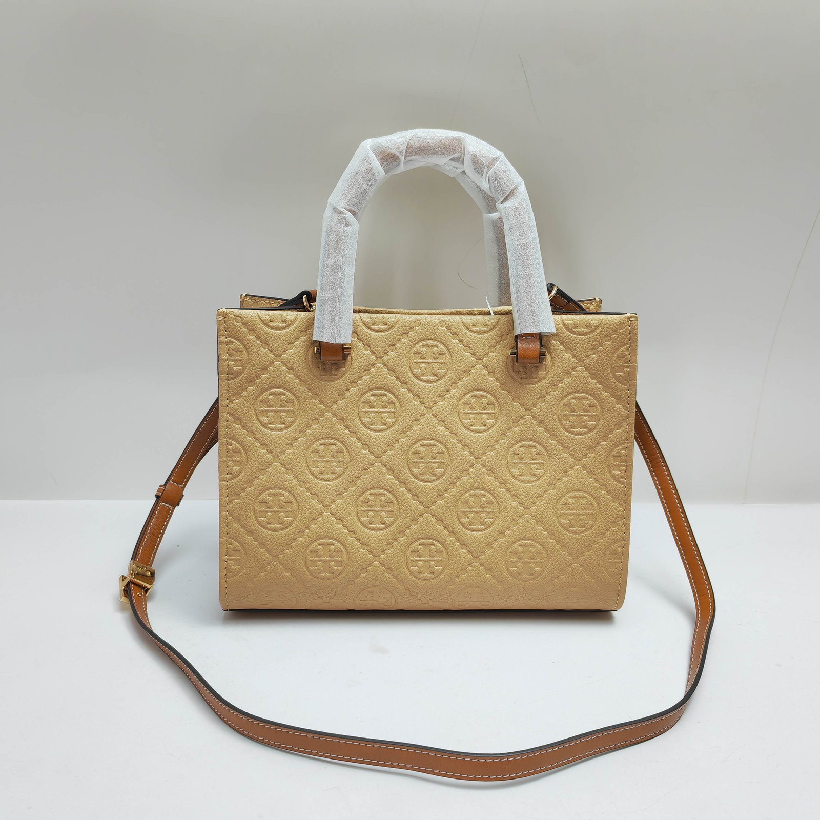 TB: TB's classic tote crossbody bag features embossed leather. Timeless charm and unique style. This cowhide tote bag comes with a detachable crossbody strap. The interior is crafted from soft, fine