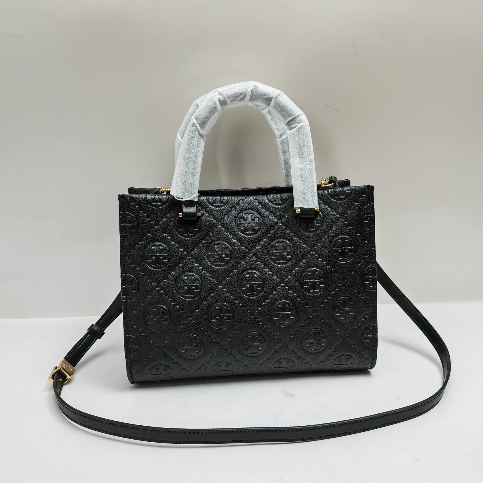 TB: TB's classic tote crossbody bag features embossed leather. Timeless charm and unique style. This cowhide tote bag comes with a detachable crossbody strap. The interior is crafted from soft, fine suede