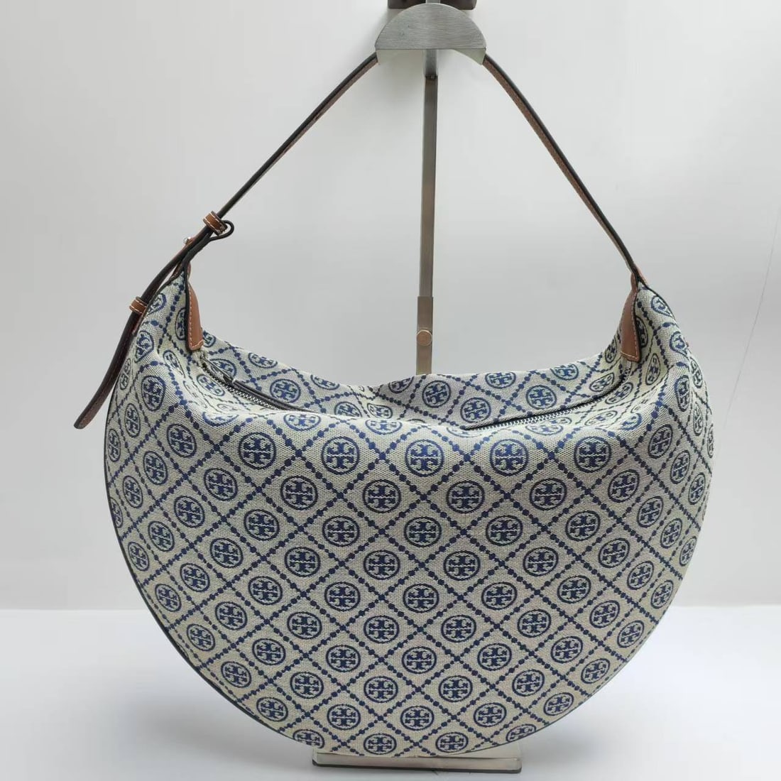 TB: ToryBurch Balloon Bag, a large crescent-shaped bag in classic Tmonogram pattern, is crafted from jacquard fabric. Its timeless charm and unique style are captivating. Echoing the Spring Summer 2025