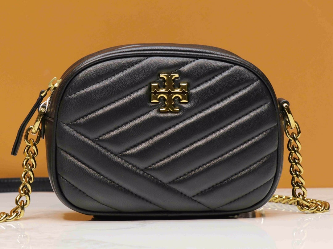 TB: This classic style has been a favorite among girls in recent years. The soft lambskin paired with the new tea-gold hardware further enhances its high-end appeal. KIRA CHEVRON SMALL CAMERA BAG, black. 