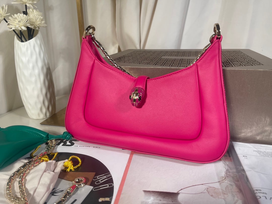 Bvlgari SERPENTI BAIA: The Bvlgari SERPENTI BAIA small shoulder bag is crafted from supple and durable fuchsia calfskin. The adjustable shoulder strap is adorned with the iconic snakehead magnetic clasp and alluring scales.