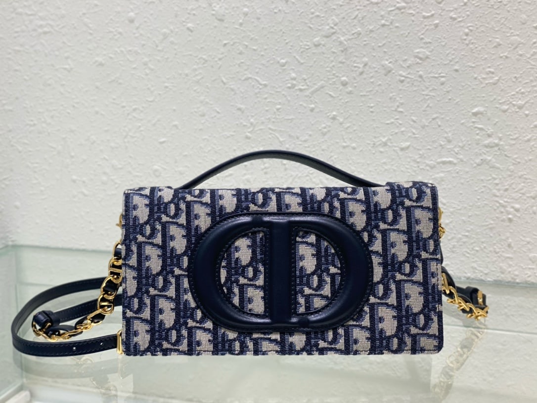 Christian Dior: The CD Signature Mini Chain Handbag in blue Oblique print is part of the Fall Winter 2023 ready-to-wear collection, designed by Maria Grazia Chiuri. It blends practical design with Dior's modern spiri