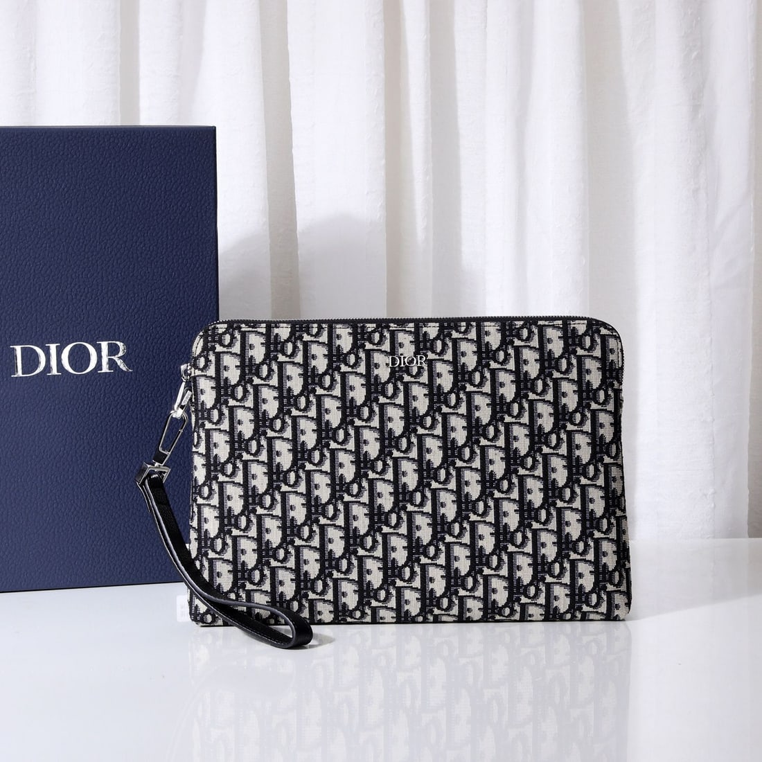 Christian Dior: This luxurious Dior clutch is meticulously crafted in the iconic beige and black Oblique print originally launched in 1967. With its elegant lines and spacious interior, it can hold a variety of every