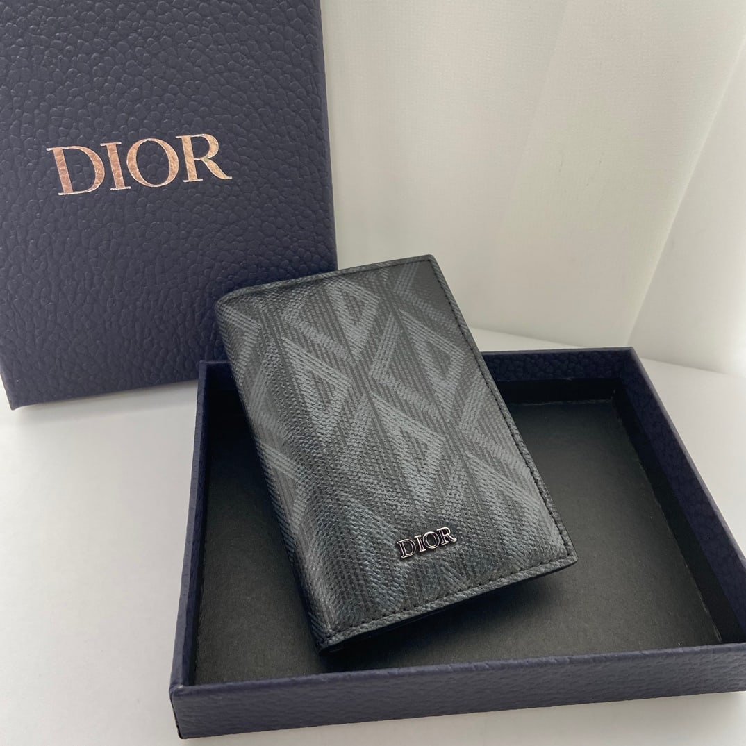 Christian Dior: This bi-fold card holder is practical yet elegant. Crafted from black CD Diamond patterned canvas, inspired by the Dior archives, it features tonal smooth calfskin details. It has three card slots on 