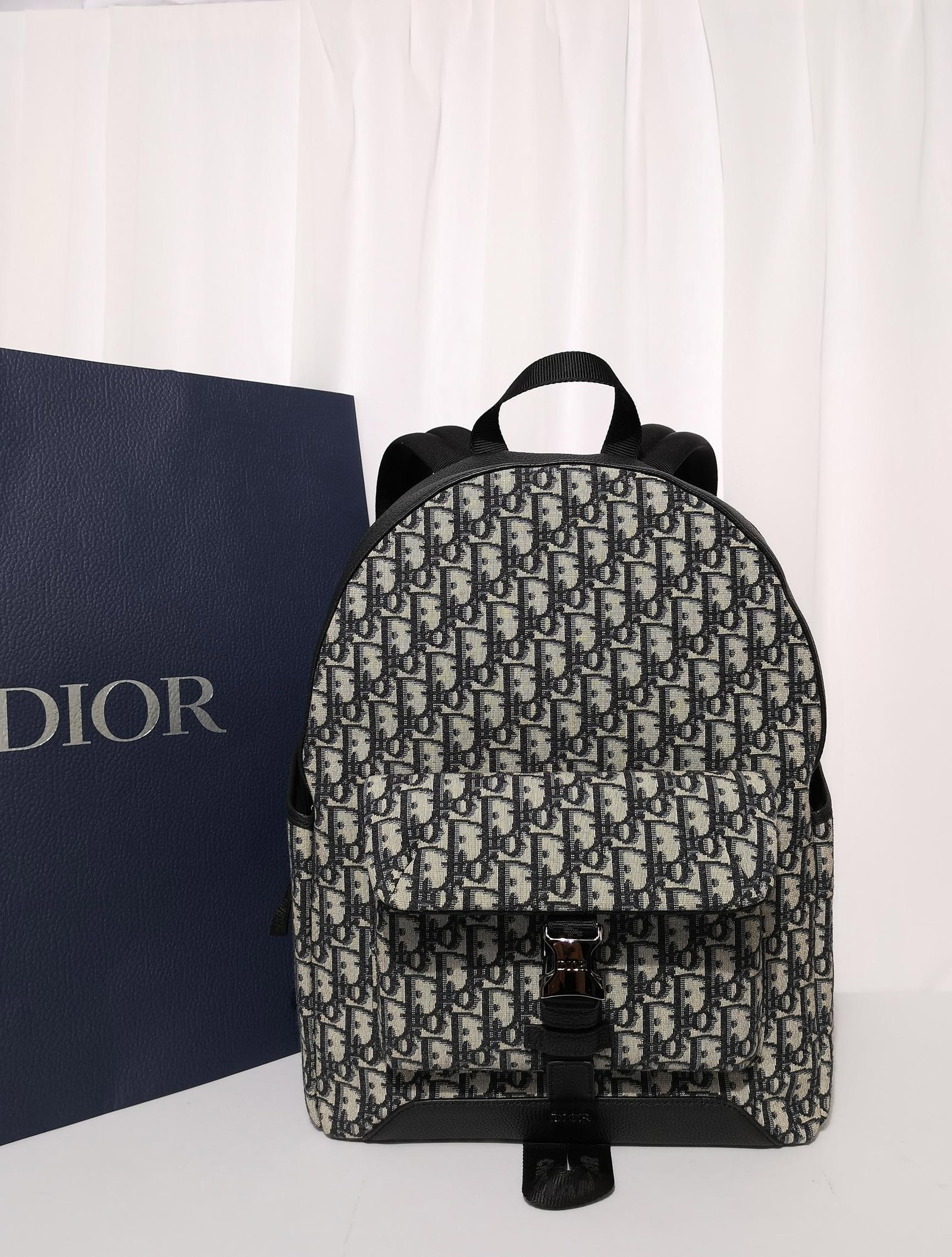 Christian Dior: This backpack is from the Dior Explorer collection. Crafted from beige and black jacquard fabric, it features an Oblique print and black grained calfskin leather, with distinctive DIOR leather patches