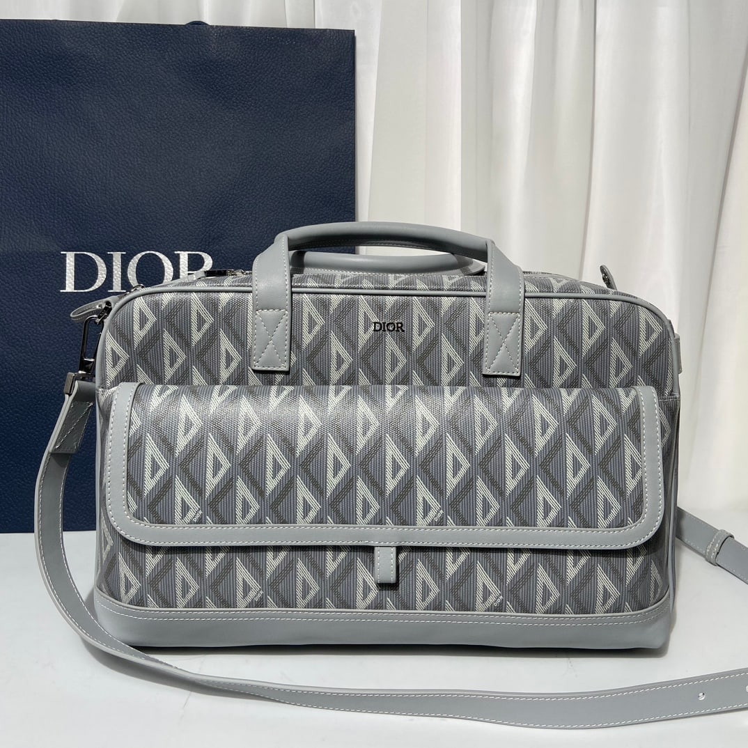 Christian Dior: The Dior Hit The Road pet carrier is adorned with the classic Dior logo. Crafted from Dior grey canvas and featuring the CD Diamond pattern, it boasts a large zip closure and a spacious interior compa