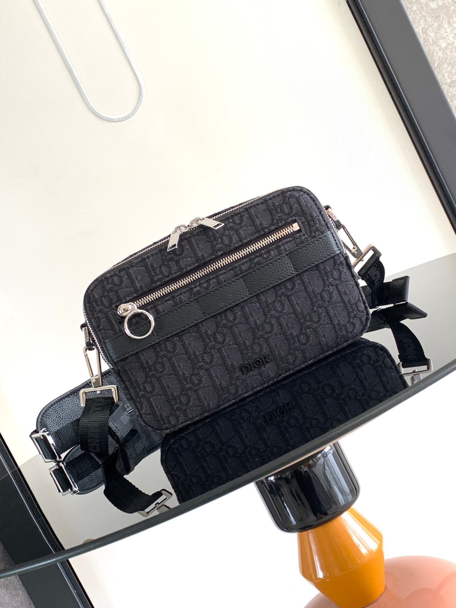 Christian Dior: The Safari messenger bag is practical and compact, perfect for everyday carry. Crafted from black Oblique printed fabric and finished with black grained calfskin leather details, it features a zippere