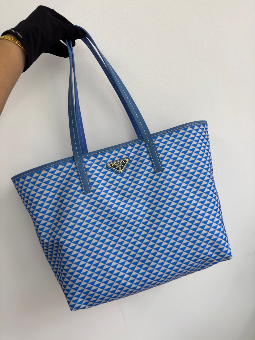 PRADA Tessuto Triangulum Tote Bag: The Tessuto Triangulum tote bag is made of imported printed nylon fabric and paired with cross-grain cowhide. Its eye-catching triangular pattern and vibrant colors, combined with its large capacity, 