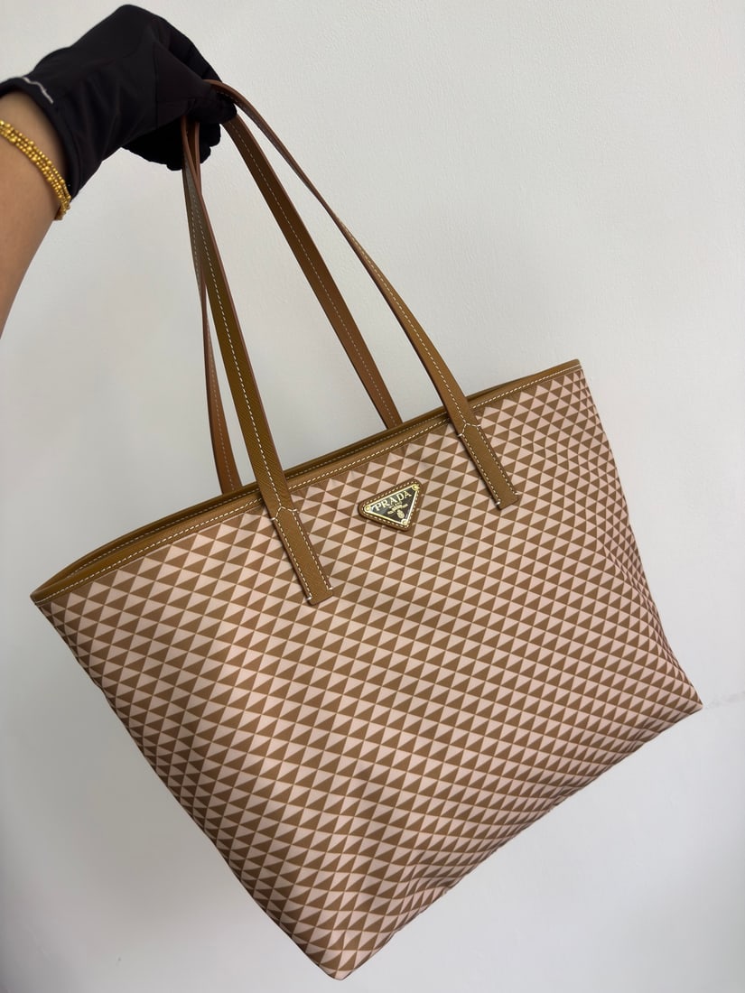 PRADA Tessuto Triangulum Tote Bag: The Tessuto Triangulum tote bag is made of imported printed nylon fabric and paired with cross-grain cowhide. The eye-catching triangular pattern and vibrant colors, combined with its large capacity, 