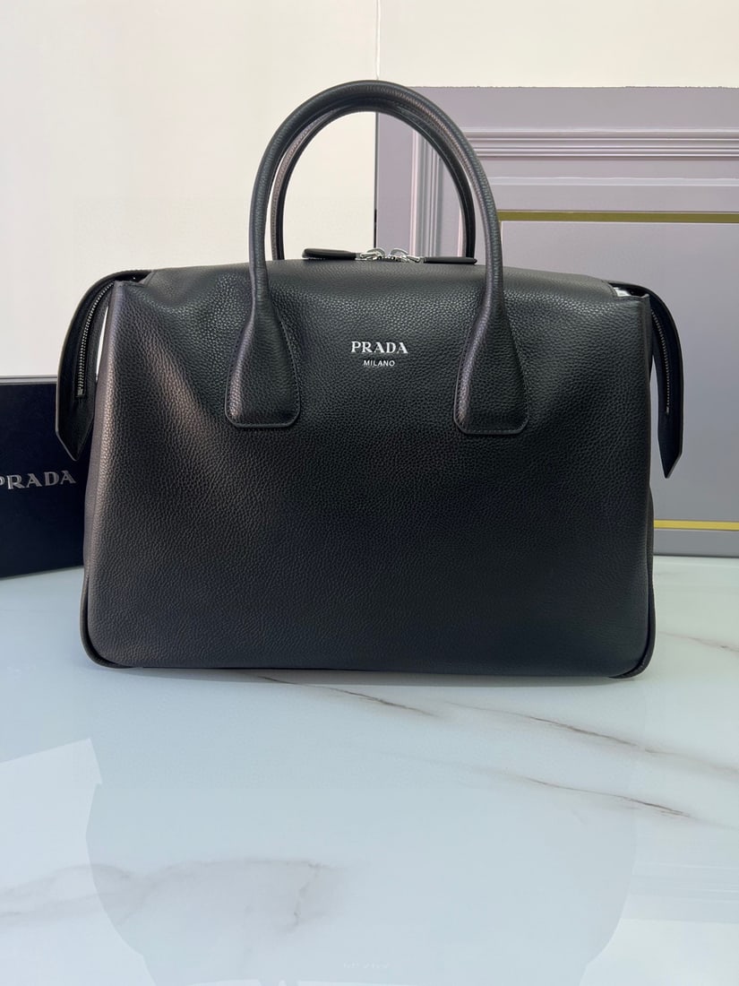 PRADA double-handled leather travel bag: This double-handled leather travel bag is made of imported calfskin, with an exceptionally soft feel and appearance. It features a heat-printed logo on the front, a zippered interior compartment with 