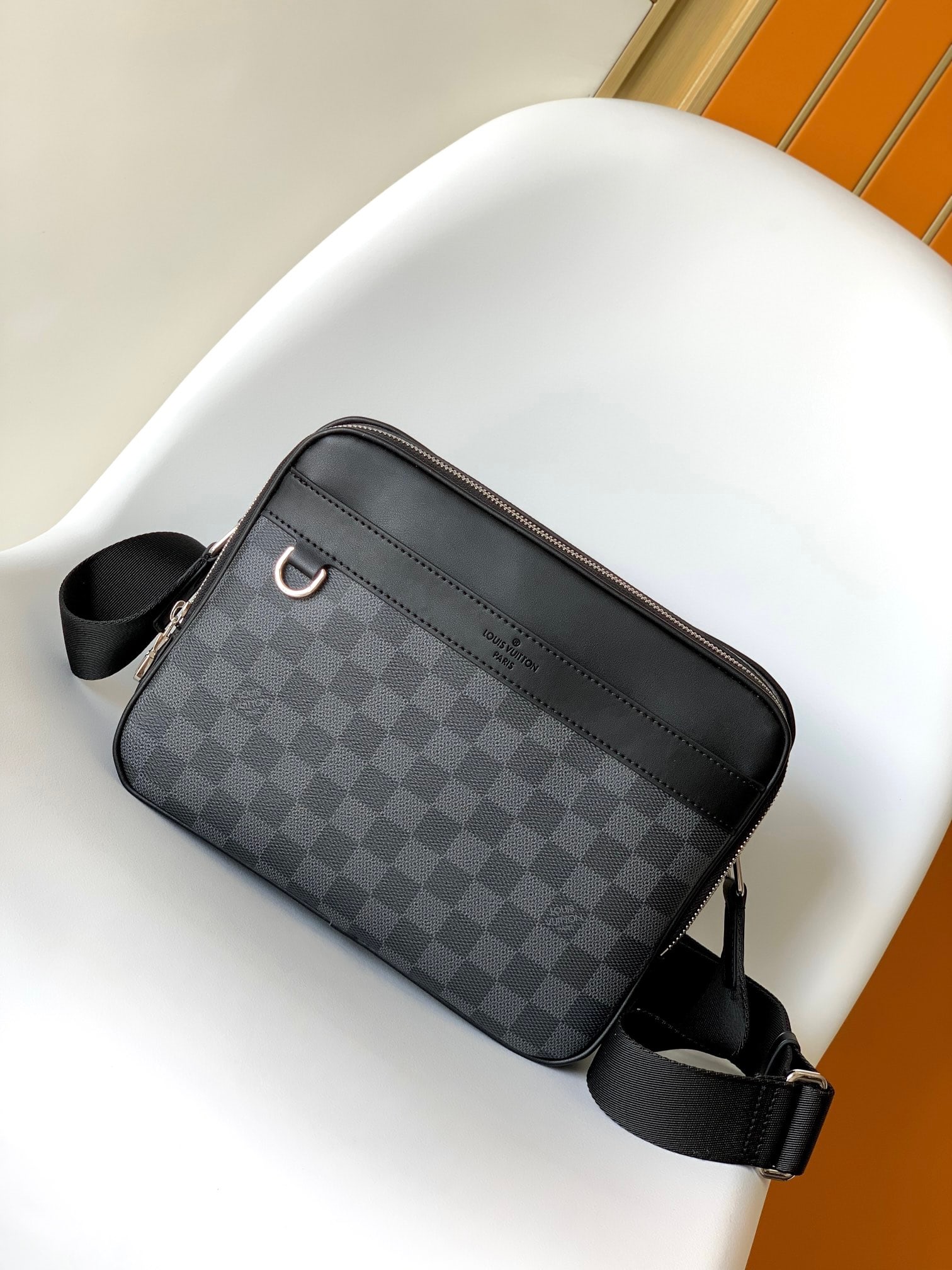 LV Trocadero NM Small Messenger Bag: The Trocadero NM Small Messenger Bag draws inspiration from the brand's archives, with exquisite leather details sculpting the vibrant lines and timeless elegance of Damier Graphite canvas. Its double