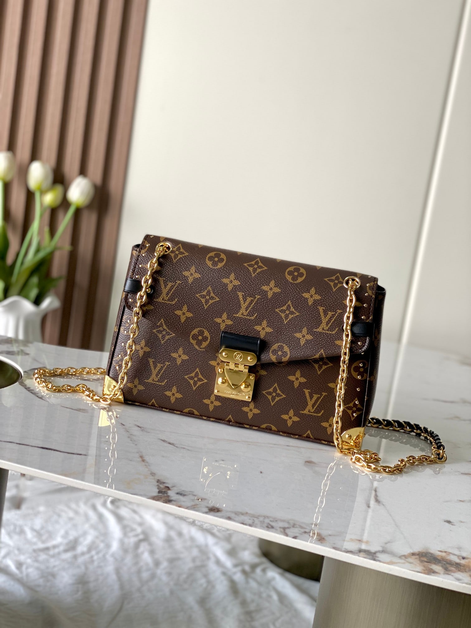 LV Trunkie: The Trunkie handbag combines Monogram canvas with metal studs, featuring metallic corner protectors and the iconic S-lock closure, showcasing the brand's heritage with a vintage trunk style. The inter