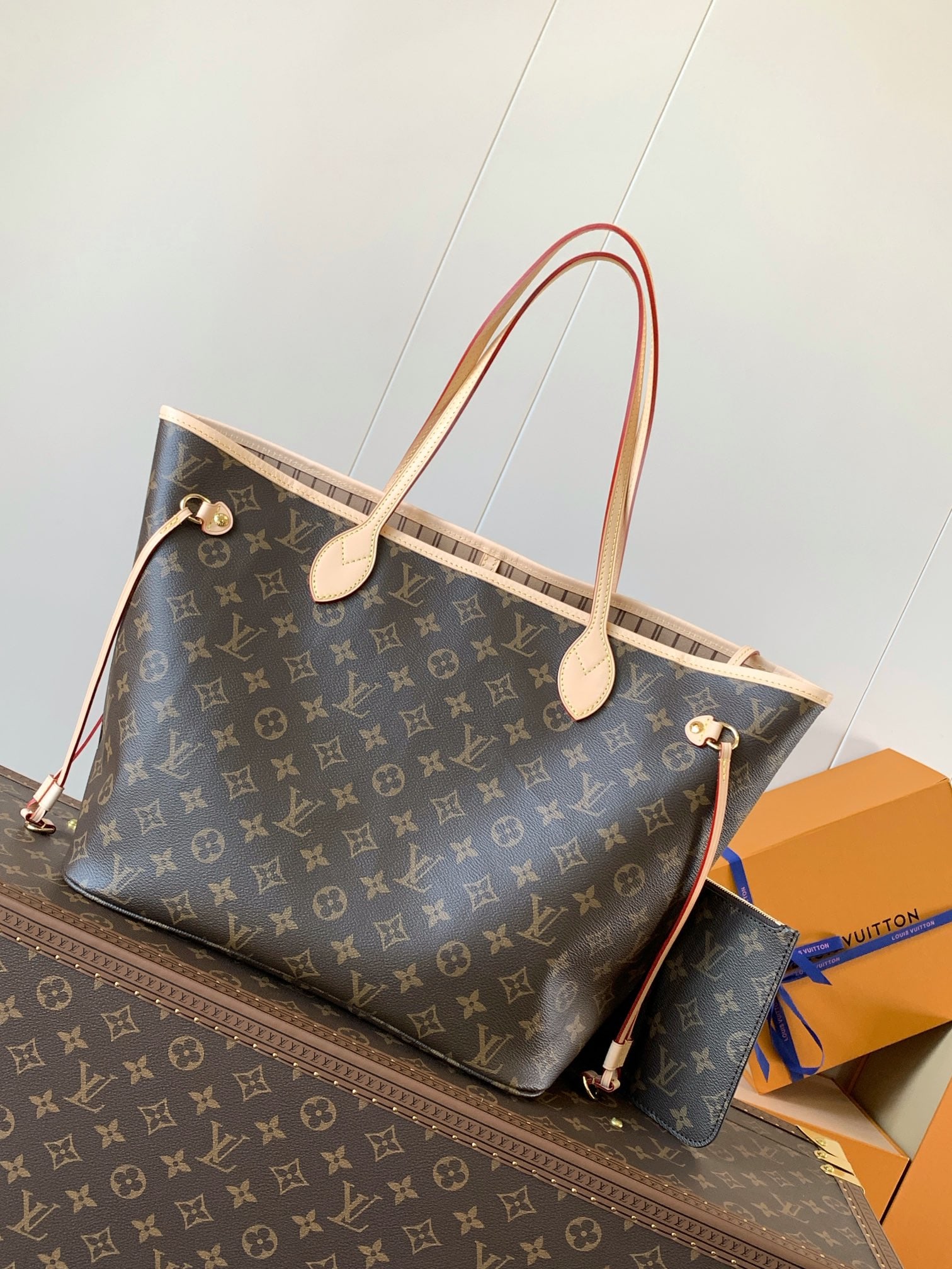 LV Neverfull: The Neverfull Medium Tote Bag features Damier Ebene canvas with cowhide leather trim, a spacious design, and a vibrant fabric lining. The side straps offer a variety of looks, whether tightened or loo