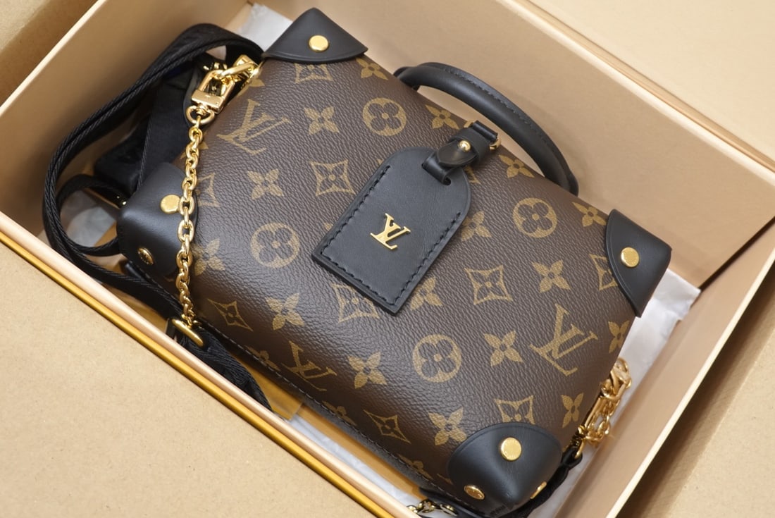 LV PETITE MALLE SOUPLE: The black Petite Malle Souple handbag is crafted from Monogram canvas, featuring studded leather trim and a leather nameplate, subtly showcasing LV's trunk-making heritage. It comes with a nautical-st
