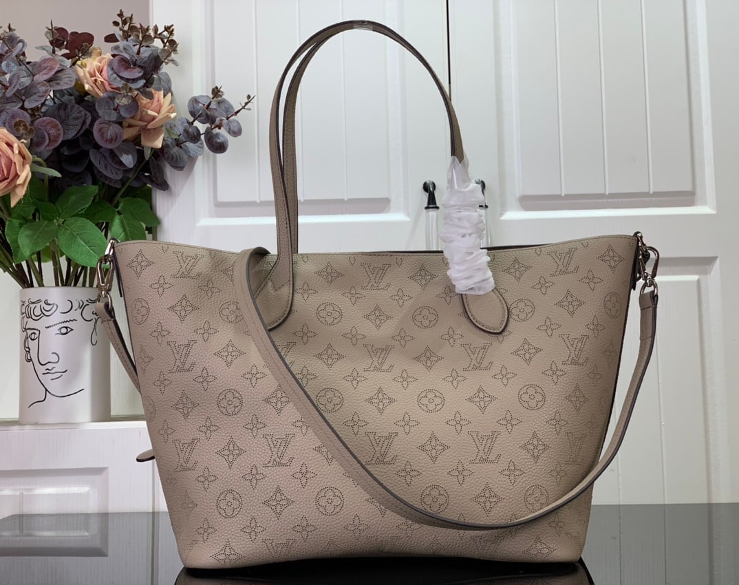 LV BLOSSOM: The BLOSSOM Medium Tote Bag is crafted from Mahina calfskin with delicate Monogram perforations. The soft, lightweight calfskin accentuates the design's drape, making it perfectly suited to the body. 
