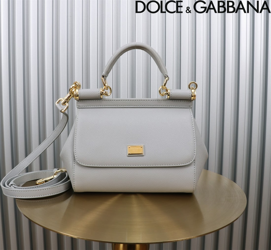 Dolce & Gabbana: The iconic Dolce & Gabbana Sicily is now presented in a compact version, offering easy storage for frequently used items. Its unique design features a hidden magnetic closure on the front flap. Size: 
