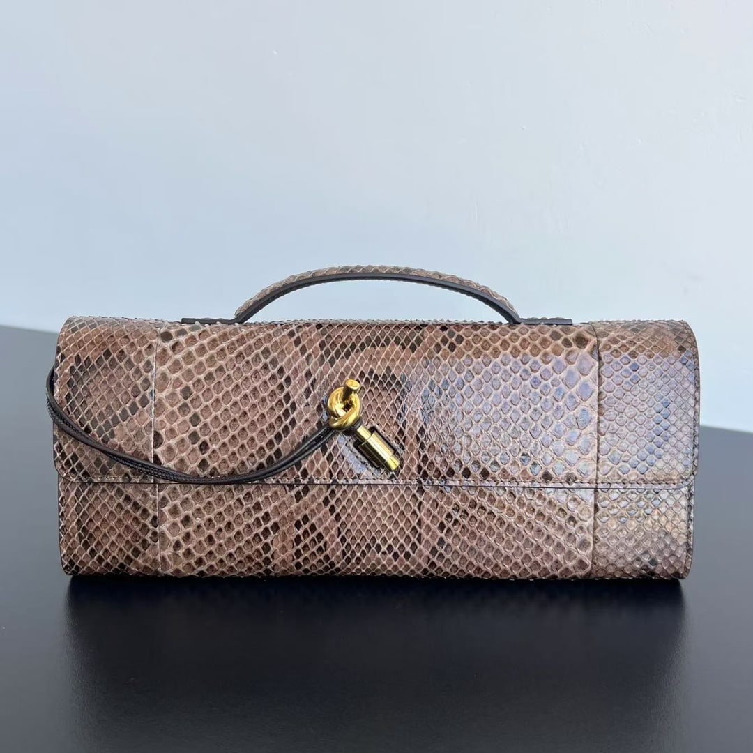 Bottega Veneta Clutch: The Bottega Veneta snakeskin clutch instantly makes this bag stand out, as if telling its own story. The rare snakeskin material and metal rope knot clasp design, along with the zippered interior, mak