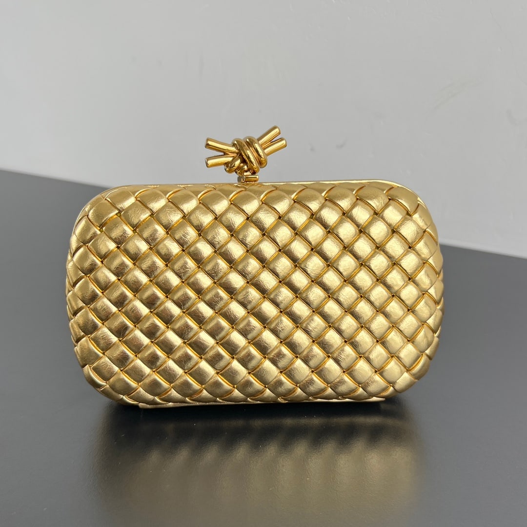 Bottega Veneta Knot Evening Clutch: The Bottega Veneta Knot evening clutch features the iconic woven texture and a metal knotted clasp, exuding elegance and sophistication. The soft, comfortable lambskin leather and the knotted metal ac
