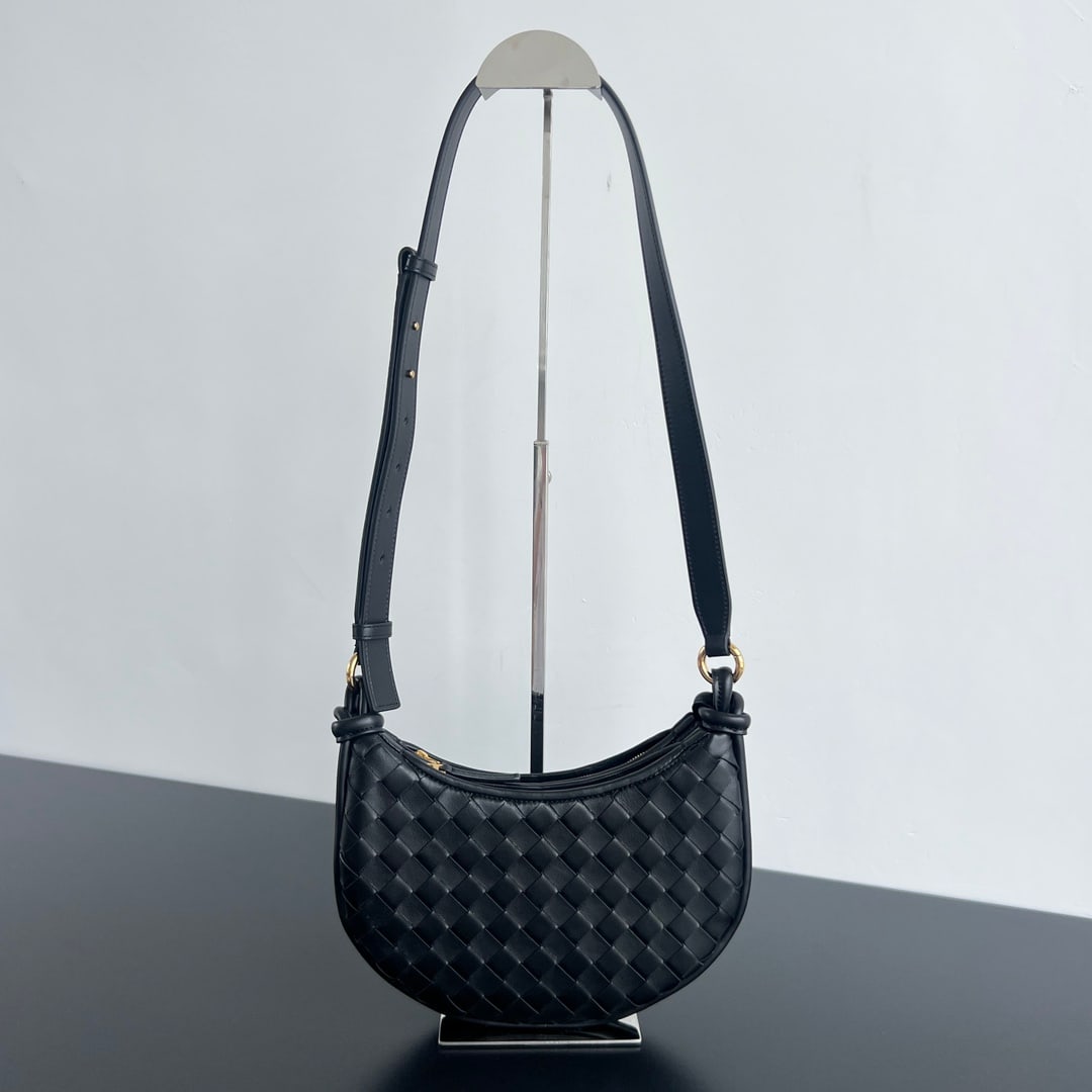 Bottega Veneta Gemelli: The Bottega Veneta Gemelli half-moon crossbody bag echoes the "power of layering" with its design, consisting of two half-moon shaped bags connected by the brand's classic knot. The matte lambskin lea