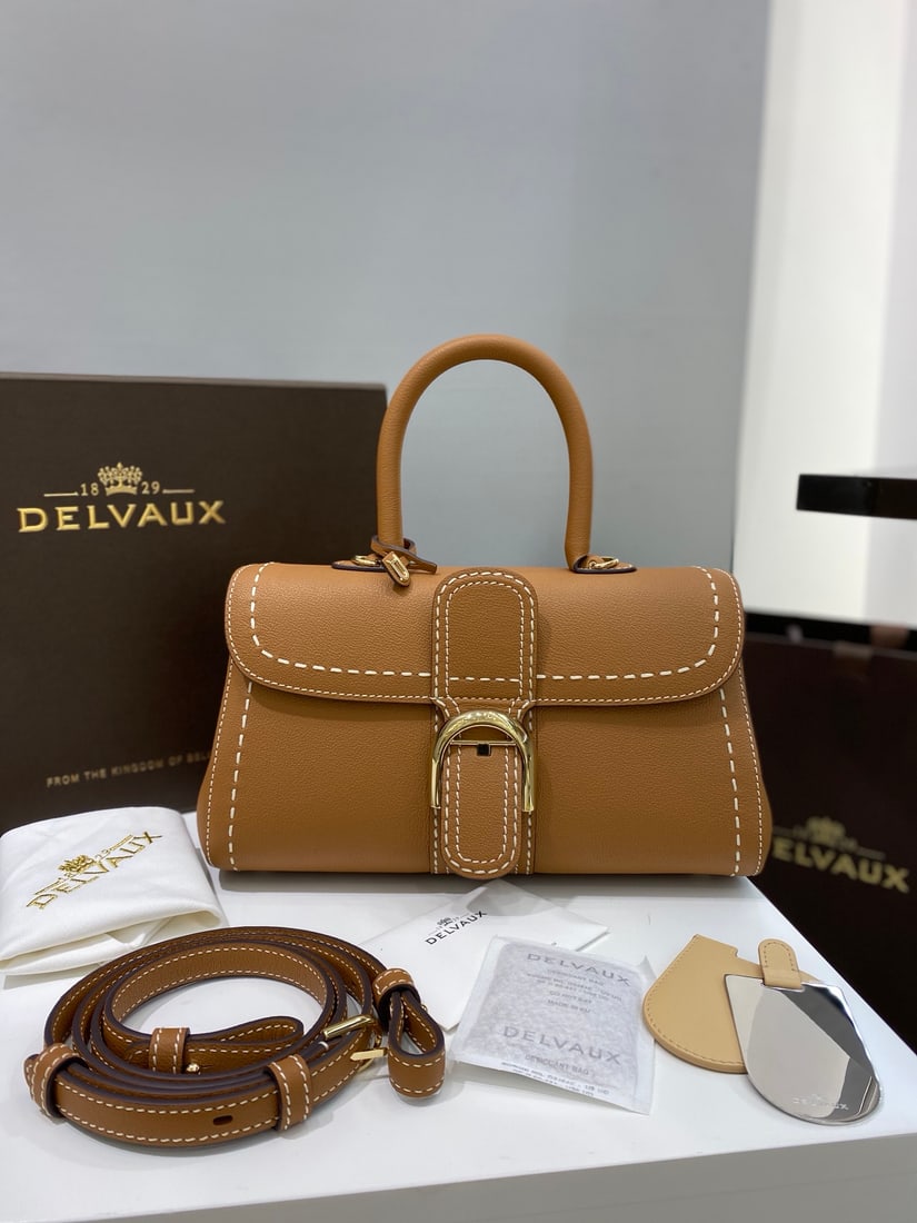 Delvaux brillant: Delvaux brillant, a Belgian royal warrant holder with a caramel-stitched exterior, exudes understated luxury with semi-hand-stitched waxed thread. Comes with an adjustable shoulder strap and a mirror.
