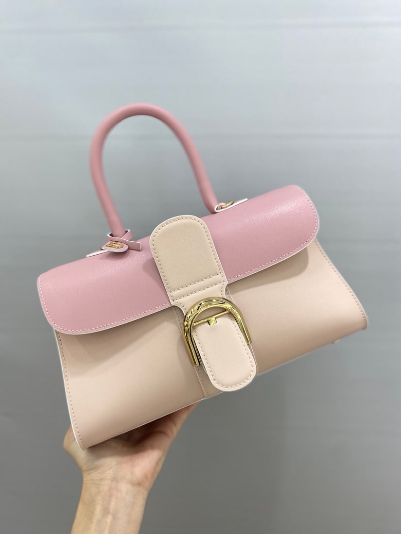 Delvaux brillant: This pink tri-tone Delvaux brillant, a Belgian royal warrant holder, features a double-ring brillant box leather upper with lambskin lining, an adjustable long shoulder strap, a mirror, and a small ch