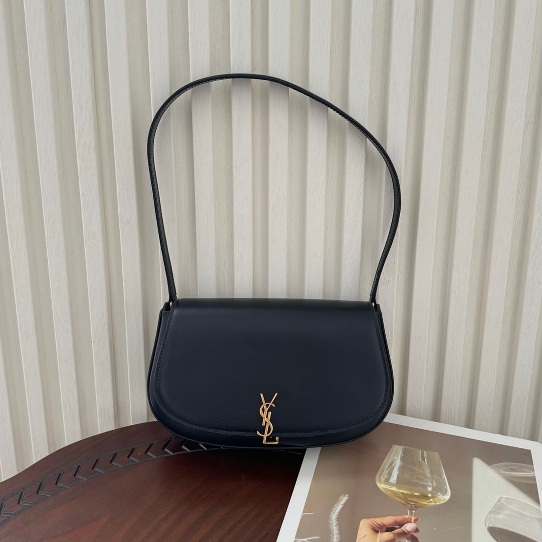 Yves Saint Laurent Voltaire half-moon shaped calfskin underarm bag: The Voltaire half-moon shaped cowhide underarm bag features clean, crisp lines and a retro feel. The Le Cassandre twist closure is novel. It's versatile enough to match any outfit, from elegant dresse