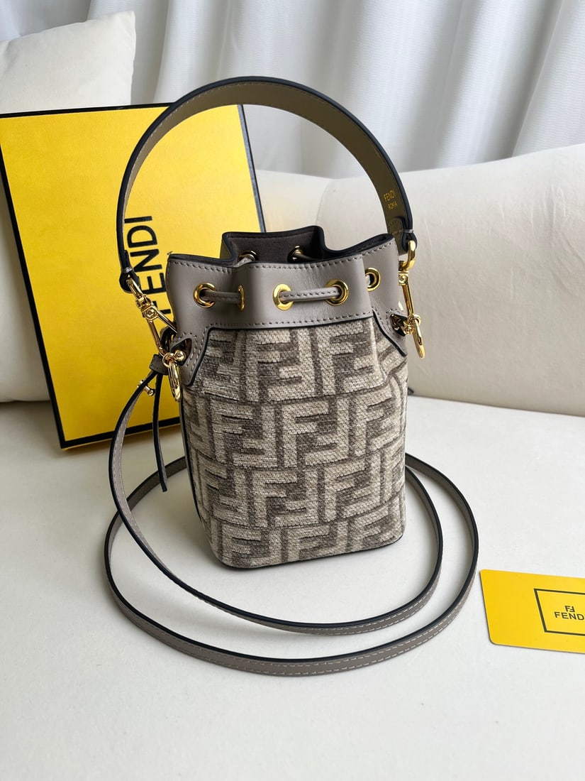 Fendi Mon Tresor: Mon Tresor mini bucket bag in dove grey canvas and light blue leather. Features a drawstring closure and Fendi metal logo embellishment. Comes with two detachable shoulder straps (one long, one short)