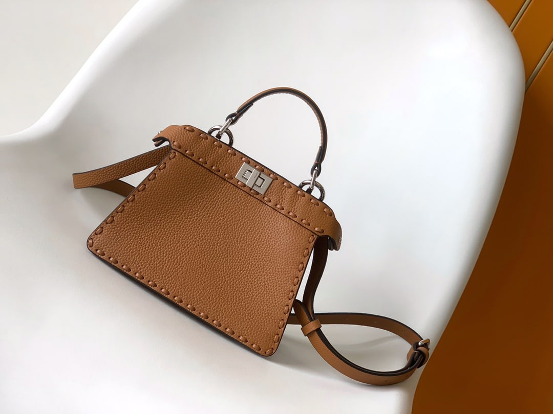 Fendi conic Peekaboo ISeeU Mini: Brown Fendi conic Peekaboo ISeeU Mini calfskin leather, large size with tonal stitching and hand-stitched details. Features a classic twist lock, two compartments, handle, and adjustable detachable sh